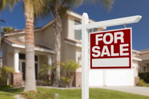 Home For Sale Real Estate Sign in Front of Beautiful New House.